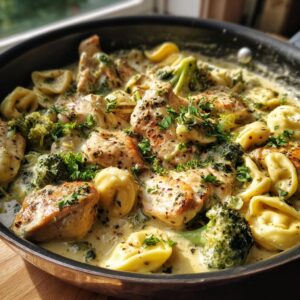 A close-up of Garlic Parmesan chicken broccoli tortellini in a creamy sauce, garnished with parsley.