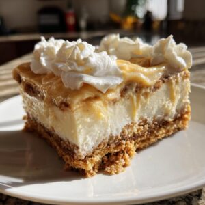 A decadent slice of no bake pecan pie lasagna topped with whipped cream and a caramel drizzle.
