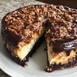 A rich german chocolate cheesecake with a slice cut out, showing the dark crust, creamy filling, and pecan caramel topping.