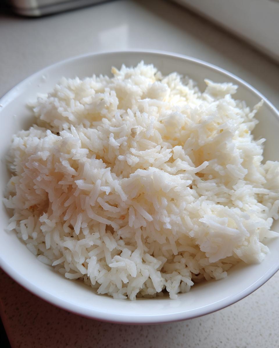 Close-up of fluffy, white basmati rice mixed with butter in a white bowl, representing the amazing 1-pot butter rice.