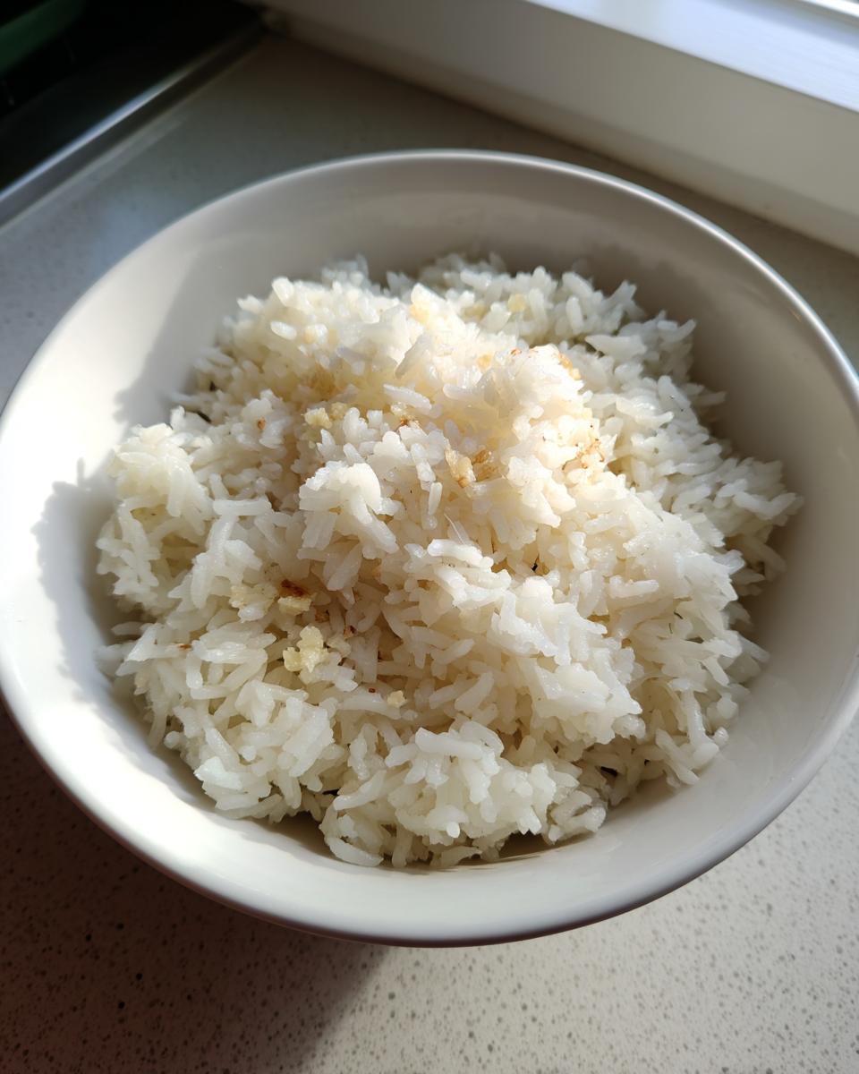 Close-up of fluffy white rice seasoned with butter, served in a white bowl.