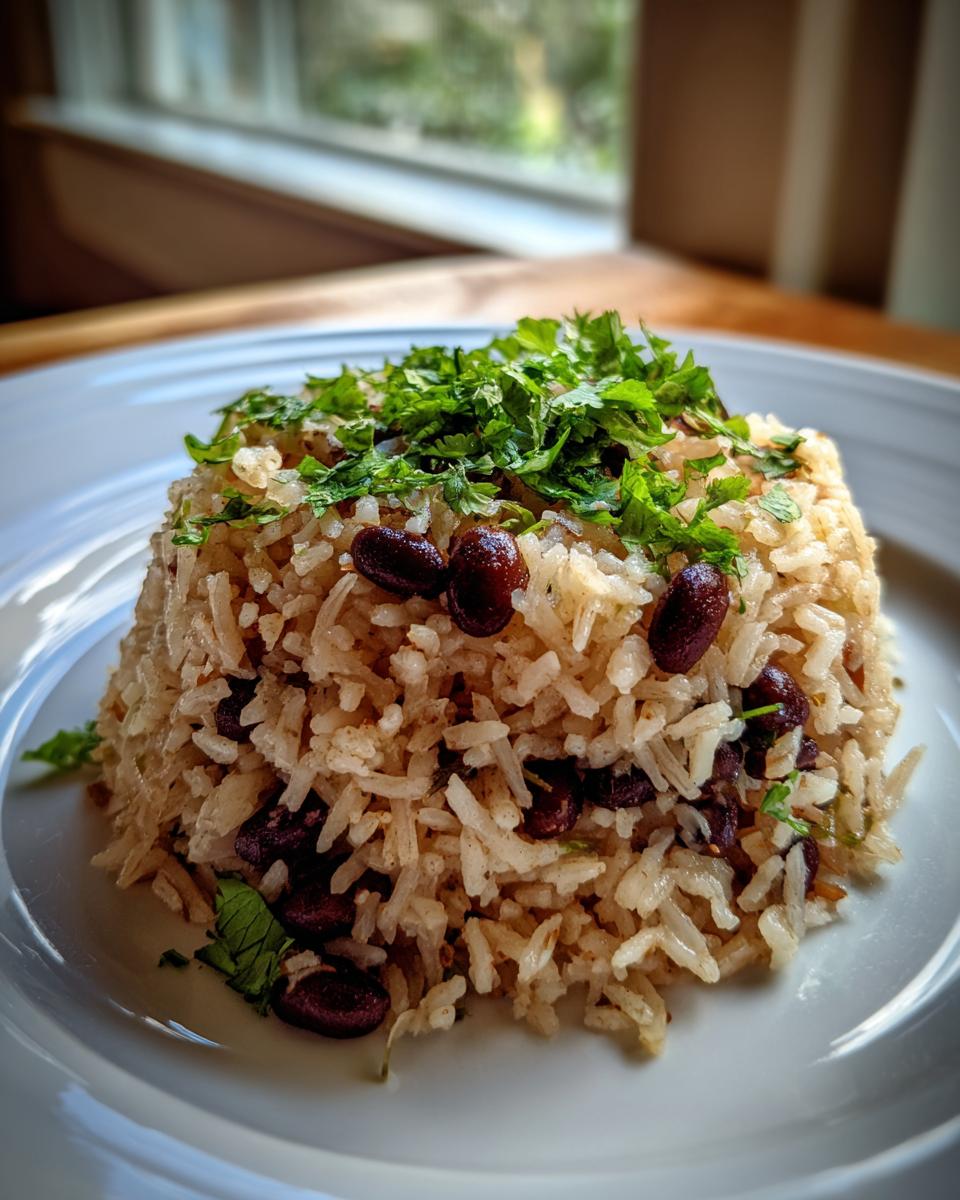 A molded serving of flavorful black beans and rice topped generously with fresh chopped cilantro.