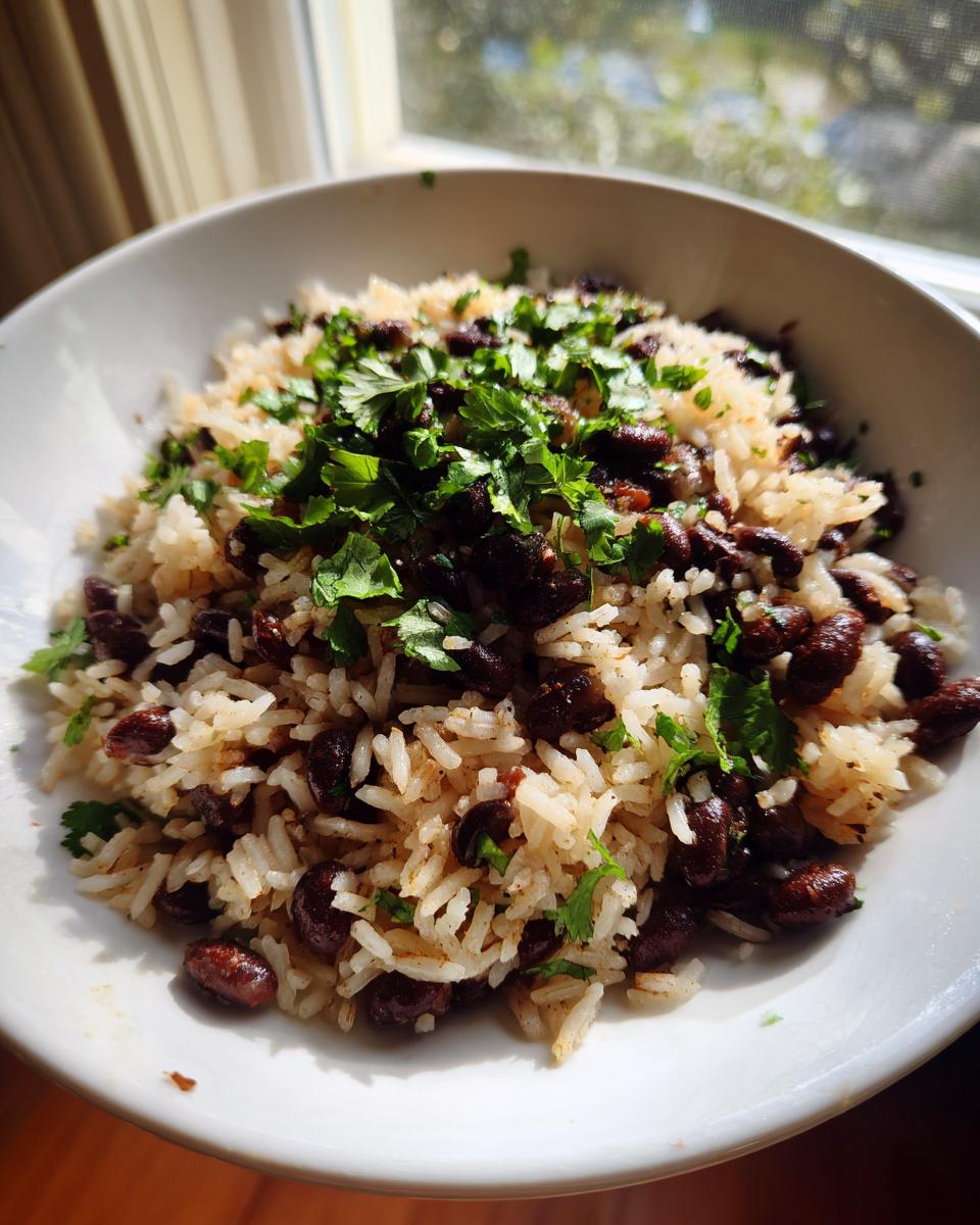 A white bowl filled with flavorful black beans and rice, topped generously with fresh chopped cilantro.