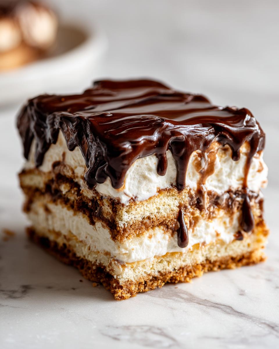 Close-up of a layered slice of chocolate eclair cake with cream filling and rich chocolate ganache dripping down.