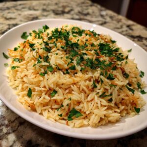 A white bowl filled with fluffy rice pilaf, garnished generously with fresh chopped parsley.
