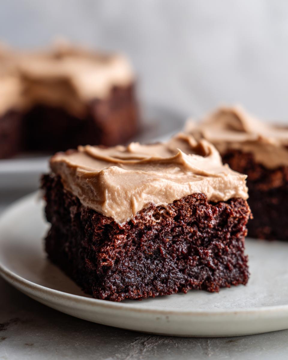 Close-up of a rich, dark chocolate banana bread brownies square topped with creamy peanut butter frosting.