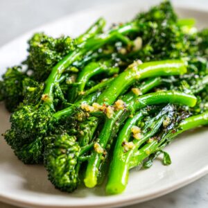 Close-up of bright green, sautéed broccolini tossed with minced garlic.