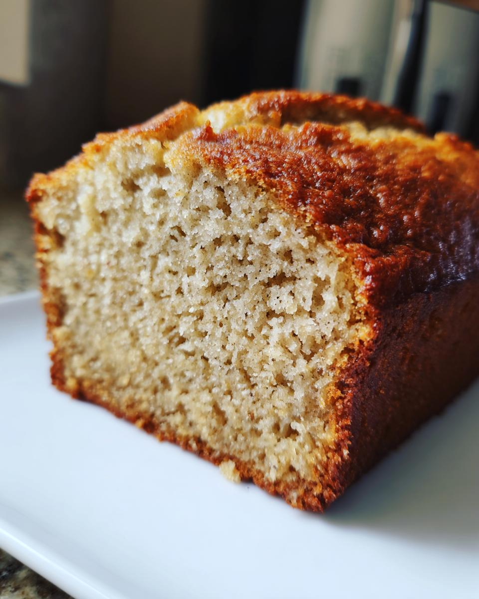 Close-up of a moist slice of sourdough banana bread showing the fine, soft crumb and golden-brown crust.
